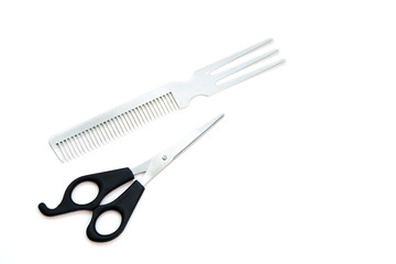 Scissors and comb on white background.