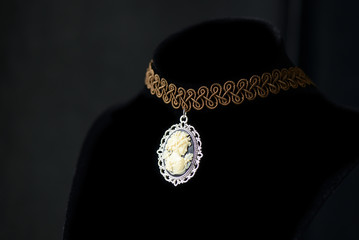 Choker necklace with girl cameo pendant on a dark background close up
