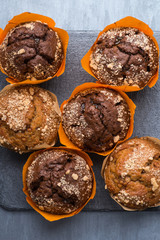 appetizing round cupcakes on a black plate, top view