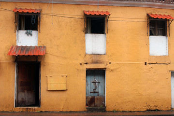 Fototapeta na wymiar Translation: the yellow vintage and colorful windows and doors in Goa City.