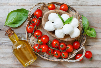 Italian cheese mozzarella with tomatoes, olive oil and herbs