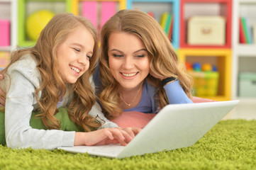 Portrait of mother and daughter using laptop