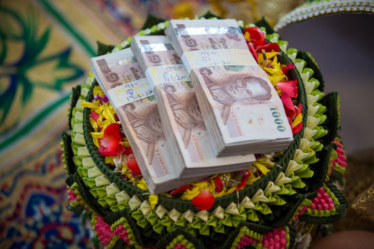 Focus bride price in Thai wedding ceremony, gold necklace, thai banknote and wedding rings. Asian Wedding Traditions. image for background, copy space and objects.
