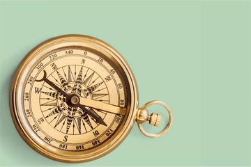 Brass antique compass on wooden background