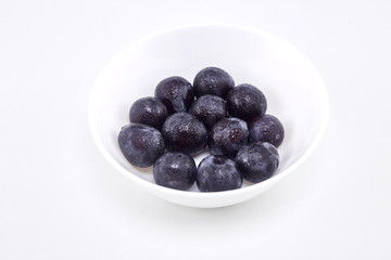 Black grape in bowl on white