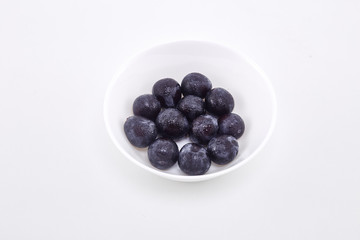 Black grape in bowl on white