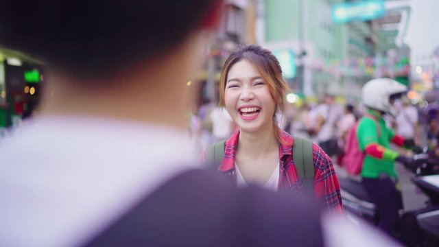 Traveler backpacker Asian couple talking while spending holiday trip at Khao San street Road and enjoy their journey travel in Bangkok, Thailand. Lifestyle Asia tourist concept.