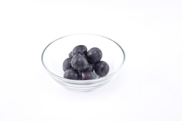 Fresh black grapes on white