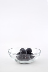 Fresh black grapes on white