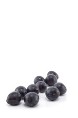 Fresh black grapes on white