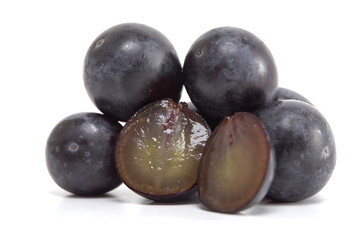 Fresh black grapes on white