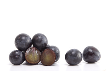 Fresh black grapes on white