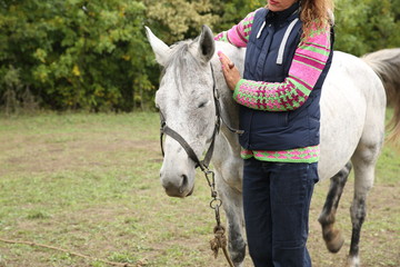 horse with sore eyes and girl vet outdoors