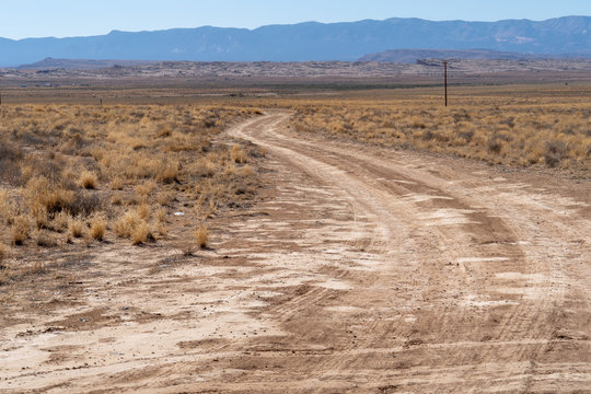 Lonely desert dirt and gravel road in rural New Mexico in the Four Corners area of the American Southwest