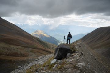 Fototapeta premium Photographer with camera and tripod in the mountains