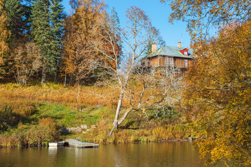 Beach with a jetty and a house on the hill in autumn