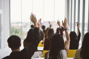 Raised up hands and arms of large group in seminar class room at Conference - obrazy, fototapety, plakaty