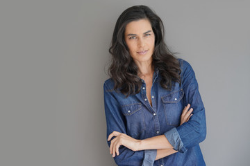 Brunette woman standing on grey background, isolated