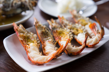 Close up Grilled prawns or fresh grilled shrimps ,cooking seafood with salad on white dish in Thai restaurant. Selective focus