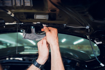 Mechanic installing car central door lock motor.