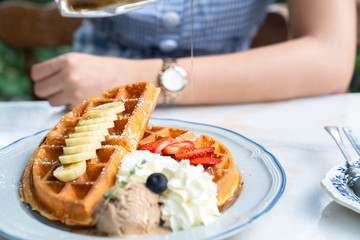 Close up honey toast dessert with ice cream, strawberry and banana in beautiful cafe restaurant