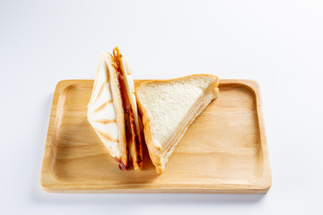 Set of baked ham cheese sandwiches on a wooden plate close up.  Isolated on white background.