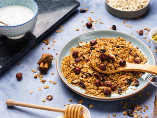 Homemade granola with honey, raisins, cherries, sesame and chestnuts on blue