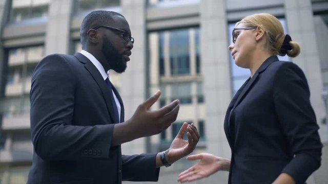 Businesswoman and male colleague quarreling, gender equality, no discrimination
