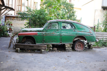 Obraz na płótnie Canvas Very old Soviet car which no longer goes because the broken is standing in the middle of the street in the city