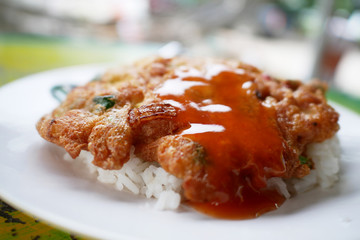 Omelet with chilli sauce on cooked rice.