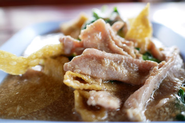 Fried egg noodle with pork  kale and cabbage soaked in gravy.