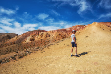 Fototapeta premium Teen boy in valley of Mars landscapes in the Altai Mountains, Kyzyl Chin, Siberia, Russia