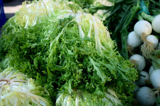 Fresh onions and green-stuff on the market counter