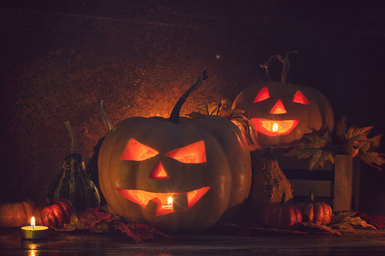 Jack O’ Lanterns glowing on the old rustic background