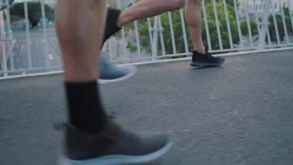 group of runners feet jogging exercising together legs friends running competitive race training workout in urban city at sunrise