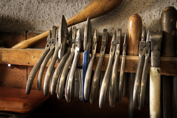different goldsmiths pliers and tools on the jewelry workplace