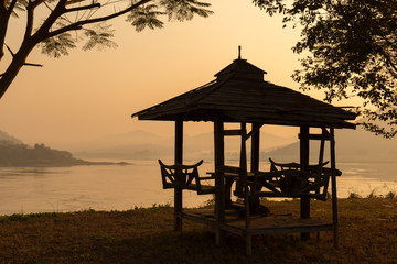 sillhouette of waterfront Pavilion in the morning.River and mountain background.