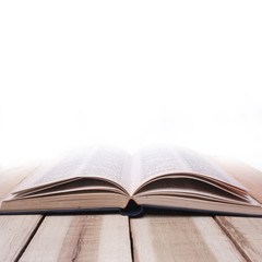 Educational concept. Opened book on wooden table against white background