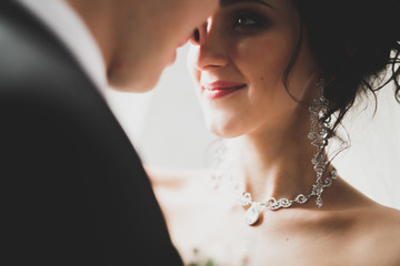 Lovely happy wedding couple, bride with long white dress posing in beautiful city