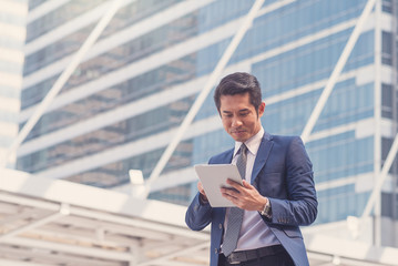 Happy Asian business man are checking their investment with a tablet.Business concept