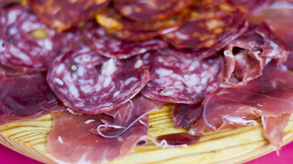 Typical spanish food with ham and sausage on a wooden plate