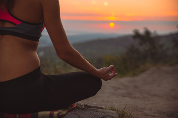 Fototapeta na wymiar woman do yoga exercises at top of the hill on sunrise