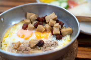 Close up breakfast food in Thai style ,Indochina pan-fried egg with pork and toppings ,salad .Selective focus ,vintage tone