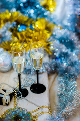 couple.  glasses with sparkling white wine on the background of a New Year's shiny decor