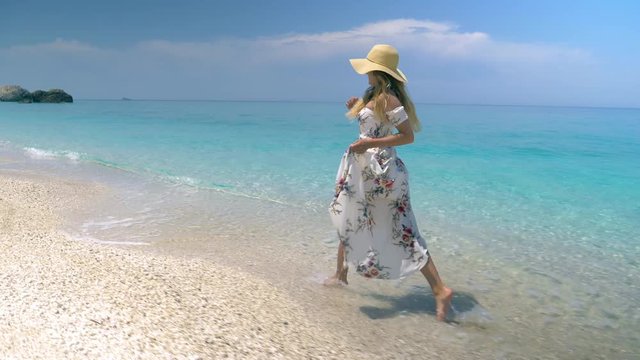 Slow motion - Young woman in white maxi dress running on paradise beach