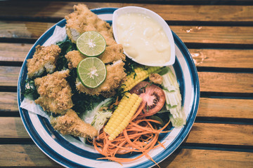 fried chicken ,salad vegetable, lemon  with Caesar Salad Dressing . selective focus ,topview . clean and healthy food concept.
