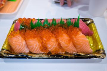 Traditional Japanese cuisine.Various kinds Sushi Set sashimi and sushi rolls. Fresh made Sushi set with salmon, prawns, wasabi and ginger in restaurant, Kuromon, Osaka ,Japan.Selective focus