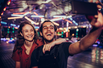 Fototapeta premium Young happy couple/ Young happy couple enjoying themselves at the amusement park