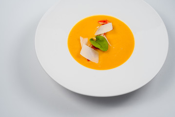 Pumpkin cream soup with slices of tender cheese