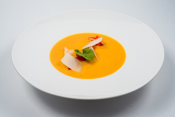 Pumpkin cream soup with slices of tender cheese